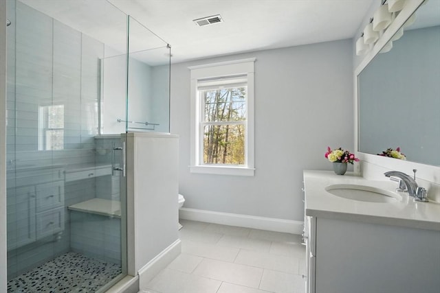 bathroom with toilet, baseboards, a shower stall, and vanity