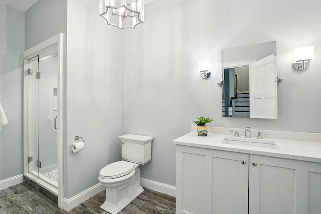 bathroom with toilet, baseboards, a shower stall, and wood finished floors