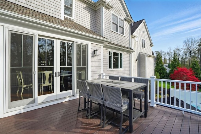 wooden terrace with french doors and outdoor dining space