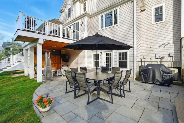 view of patio / terrace featuring stairway, outdoor dining area, and a grill