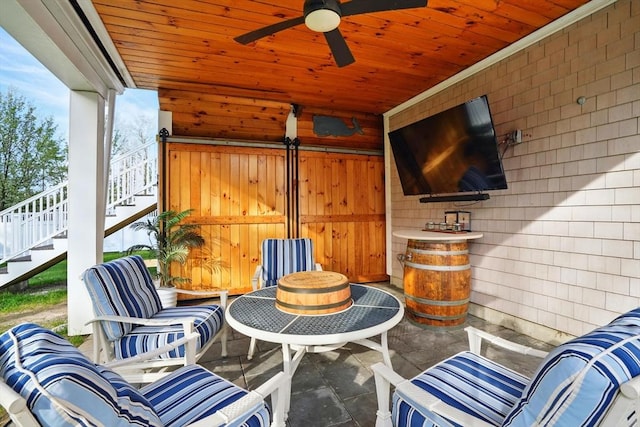 view of patio / terrace with ceiling fan and stairway