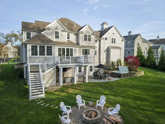 rear view of house featuring a wooden deck, a patio, a lawn, an outdoor fire pit, and stairway
