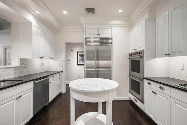15 Marlborough St Unit 3, Boston, MA 02116 - kitchen with appliances with stainless steel finishes, dark wood-style flooring, white cabinets, tasteful backsplash, and crown molding