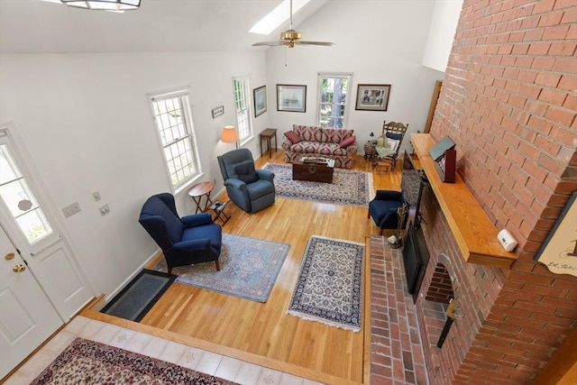 12 Robin Ln, Pepperell, MA 01463 - living area with wood finished floors, high vaulted ceiling, ceiling fan, baseboards, and brick wall