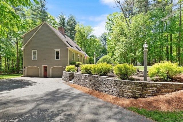 12 Robin Ln, Pepperell, MA 01463 - view of side of property with driveway, an attached garage, and a chimney