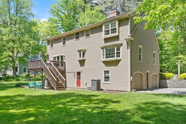12 Robin Ln, Pepperell, MA 01463 - back of property with an attached garage, a chimney, stairs, concrete driveway, and a wooden deck