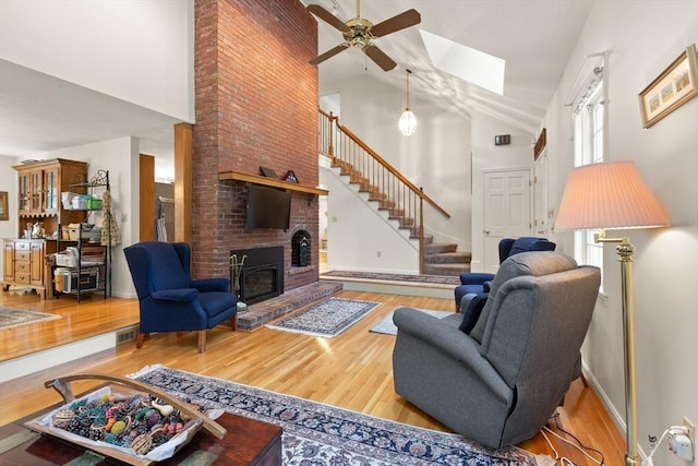 12 Robin Ln, Pepperell, MA 01463 - living area with high vaulted ceiling, wood finished floors, ceiling fan, stairs, and a fireplace