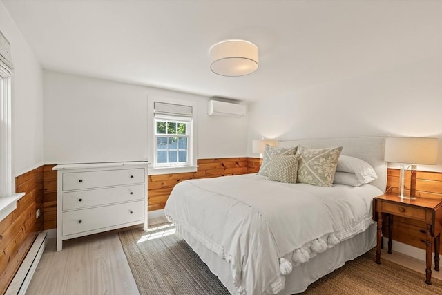 20 Judys Ln, Chatham, MA 02633 - bedroom with a baseboard radiator, a wall mounted AC, wainscoting, wood finished floors, and wooden walls