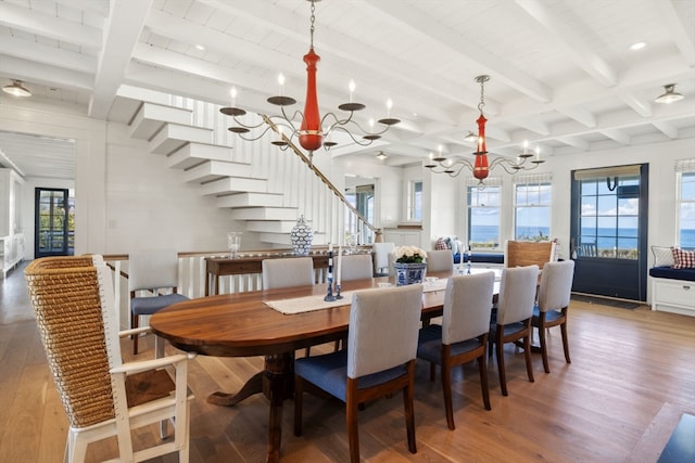 dining area featuring a notable chandelier, beamed ceiling, and hardwood / wood-style floors