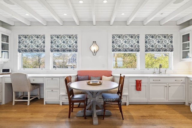 dining area featuring a healthy amount of sunlight, sink, and light hardwood / wood-style flooring