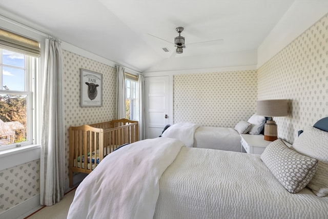 carpeted bedroom featuring ceiling fan, multiple windows, and lofted ceiling