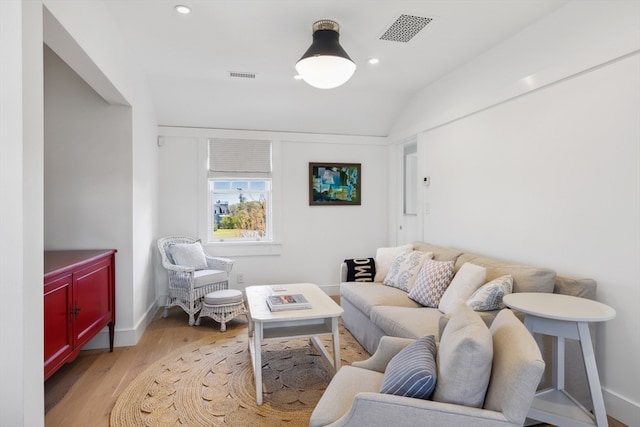 living room featuring light wood-type flooring and lofted ceiling