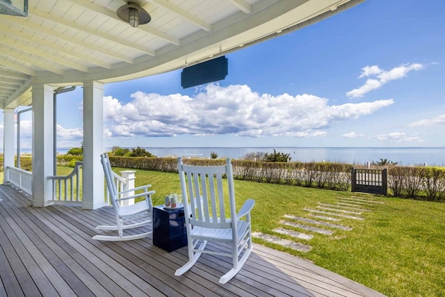 deck with a water view, a yard, and ceiling fan