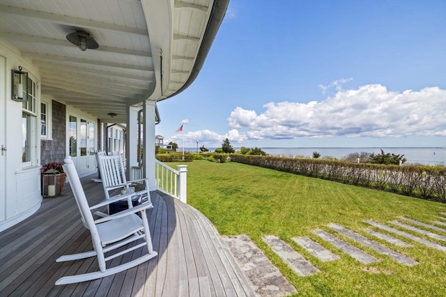 deck with a lawn and a water view