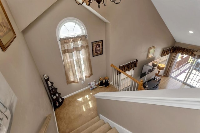 staircase with vaulted ceiling, a chandelier, baseboards, carpet flooring, and recessed lighting
