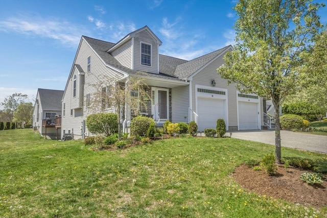 view of front of property featuring a garage, a front lawn, and driveway
