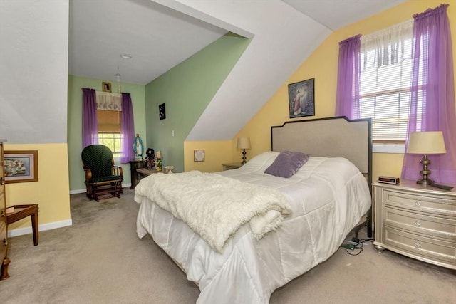 bedroom with vaulted ceiling, light colored carpet, and baseboards