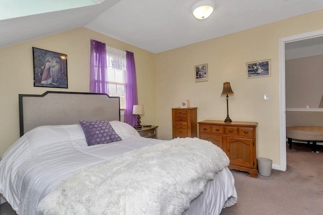 bedroom with light colored carpet, baseboards, and lofted ceiling