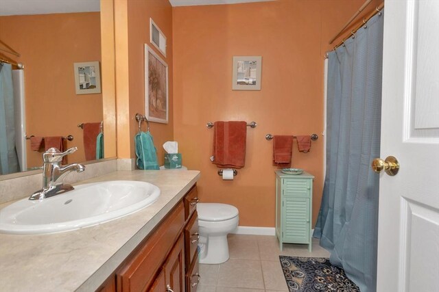 bathroom featuring tile patterned floors, toilet, vanity, baseboards, and a shower with shower curtain