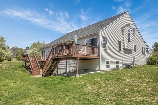 back of property with stairway, a wooden deck, roof with shingles, and a yard