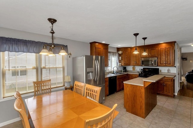 kitchen with black appliances, light countertops, a center island, a sink, and pendant lighting