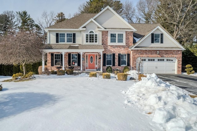 view of front of home featuring an attached garage, a shingled roof, aphalt driveway, and brick siding