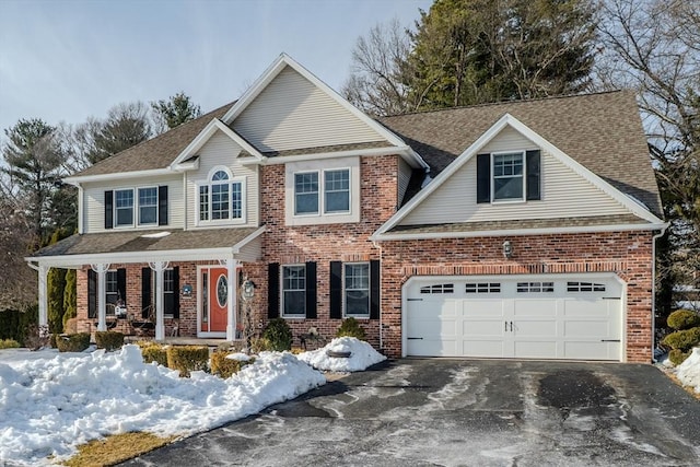 view of front of home featuring driveway, a shingled roof, a garage, and brick siding