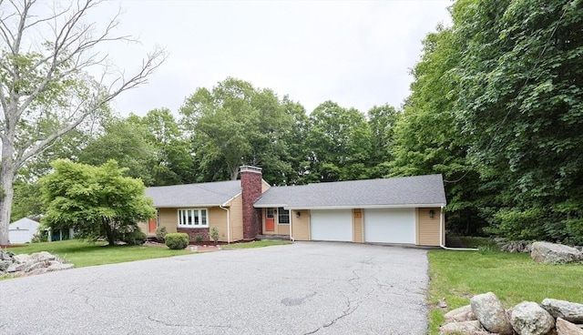 134 W Bacon St, Plainville, MA 02762 - ranch-style house with a chimney, an attached garage, a front lawn, and driveway