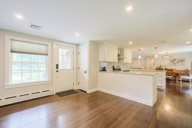 134 W Bacon St, Plainville, MA 02762 - kitchen featuring a peninsula, stove, dark wood finished floors, white cabinetry, and hanging light fixtures