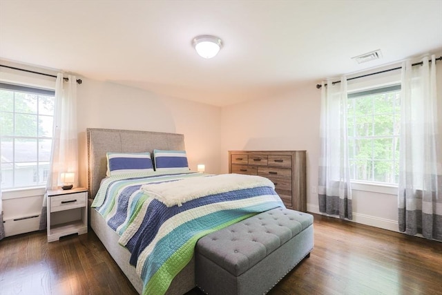 134 W Bacon St, Plainville, MA 02762 - bedroom with dark wood finished floors, multiple windows, baseboards, and a baseboard heating unit