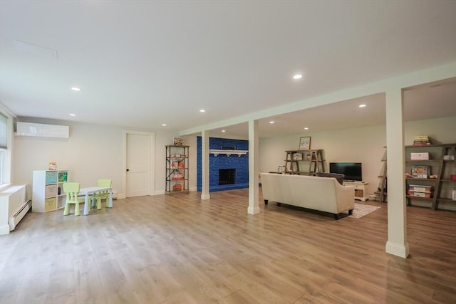 134 W Bacon St, Plainville, MA 02762 - living room with a wall unit AC, a fireplace, light wood-style flooring, recessed lighting, and baseboard heating