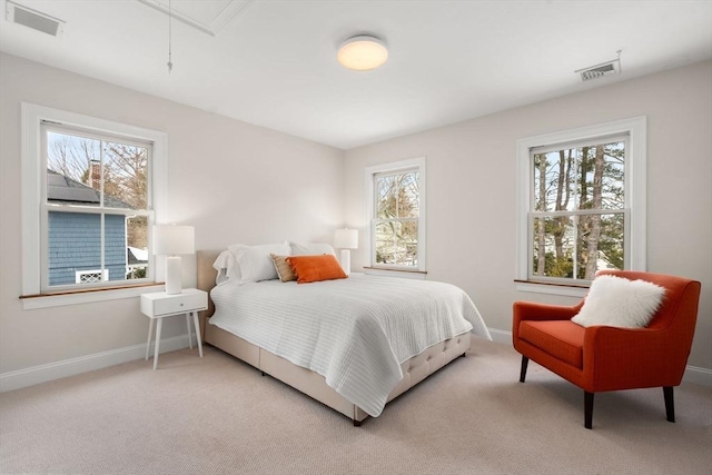 carpeted bedroom featuring attic access, visible vents, and baseboards