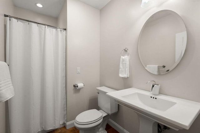 full bathroom featuring toilet and baseboards