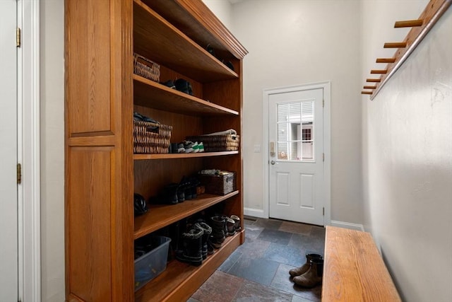 mudroom featuring stone finish flooring and baseboards