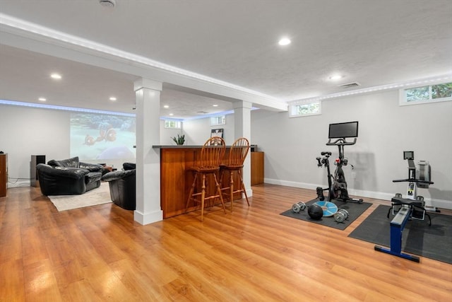 exercise area featuring visible vents, a bar, plenty of natural light, and light wood-style flooring