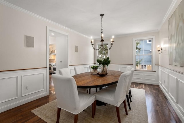 dining space featuring visible vents, dark wood finished floors, an inviting chandelier, crown molding, and a decorative wall