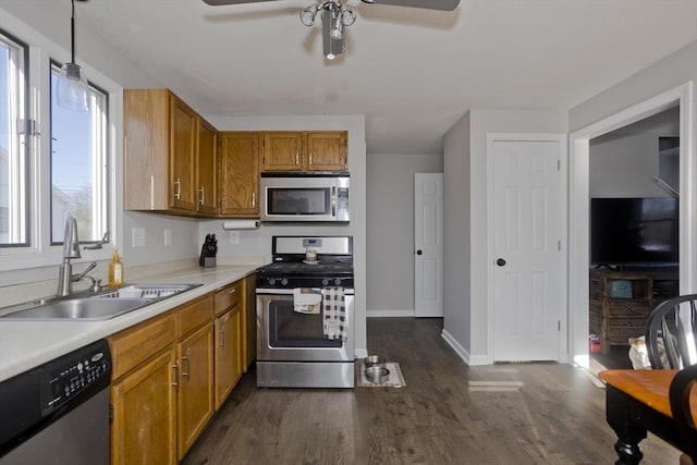 kitchen with hanging light fixtures, dark wood-type flooring, stainless steel appliances, and sink