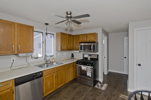 kitchen featuring sink, hanging light fixtures, appliances with stainless steel finishes, dark hardwood / wood-style flooring, and ceiling fan