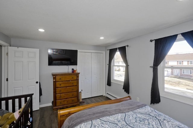 bedroom featuring a baseboard radiator, dark hardwood / wood-style flooring, and a closet