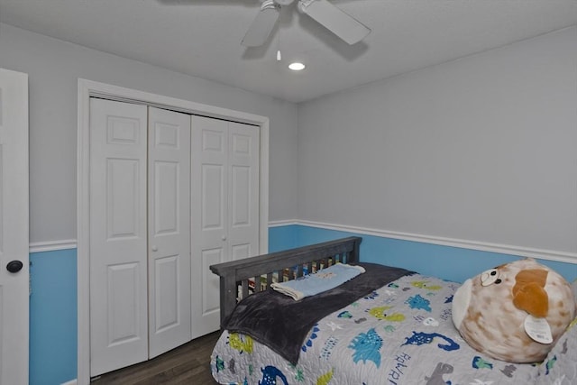 bedroom featuring dark wood-type flooring, ceiling fan, and a closet