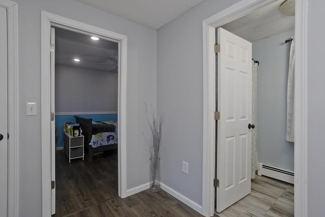 hallway featuring a baseboard radiator and hardwood / wood-style floors