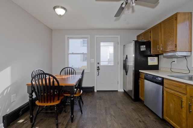 kitchen with appliances with stainless steel finishes, sink, ceiling fan, baseboard heating, and dark wood-type flooring