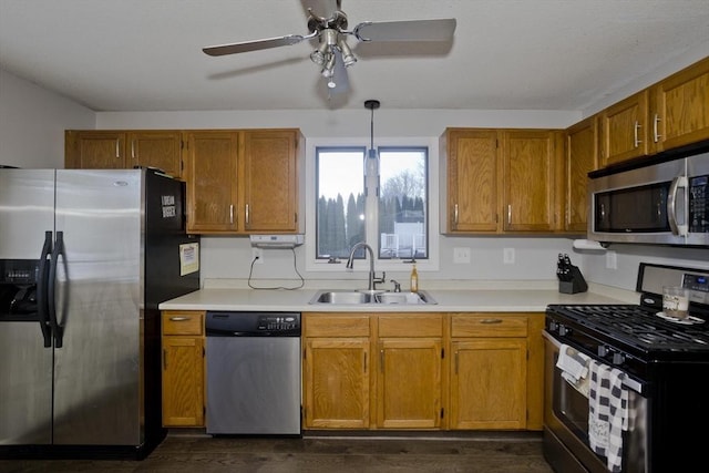 kitchen with sink, ceiling fan, hanging light fixtures, stainless steel appliances, and dark hardwood / wood-style floors