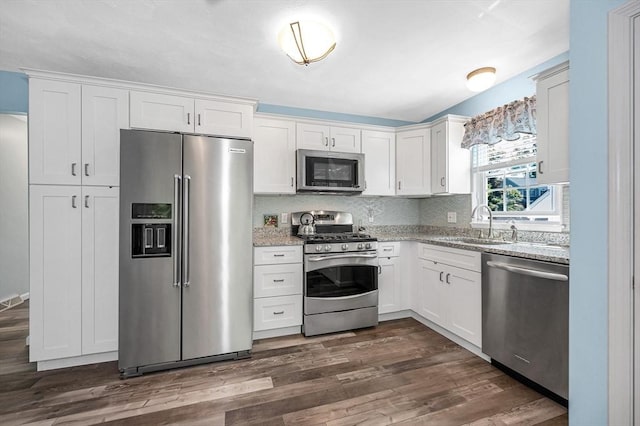 218 Acropolis Rd, Lowell, MA 01854 - kitchen featuring stainless steel appliances, white cabinetry, light stone counters, and a sink