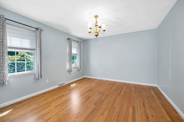218 Acropolis Rd, Lowell, MA 01854 - spare room with a chandelier, light wood-type flooring, and baseboards