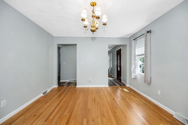218 Acropolis Rd, Lowell, MA 01854 - unfurnished dining area with a chandelier, light wood-type flooring, and baseboards