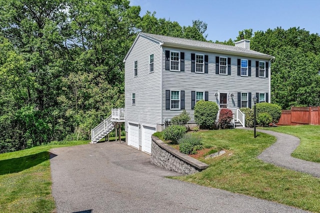218 Acropolis Rd, Lowell, MA 01854 - colonial house featuring a chimney, an attached garage, driveway, and stairway