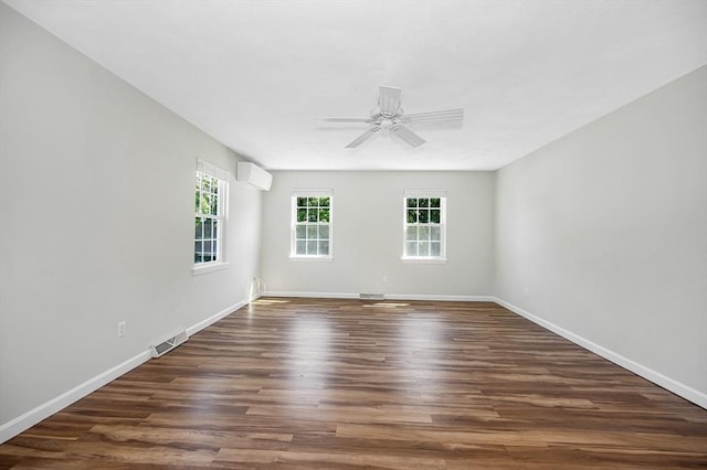 218 Acropolis Rd, Lowell, MA 01854 - empty room with a wall unit AC, dark wood-style floors, a ceiling fan, and baseboards
