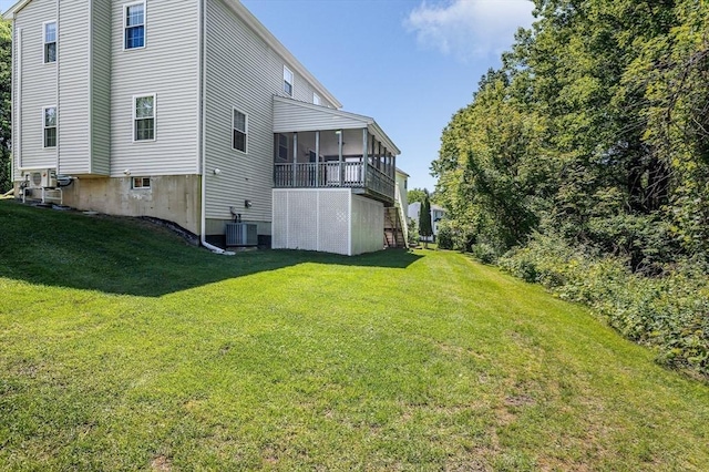 218 Acropolis Rd, Lowell, MA 01854 - rear view of house featuring a sunroom, a lawn, and central air condition unit