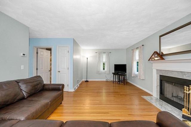 218 Acropolis Rd, Lowell, MA 01854 - living area with light wood-style flooring, a high end fireplace, and baseboards